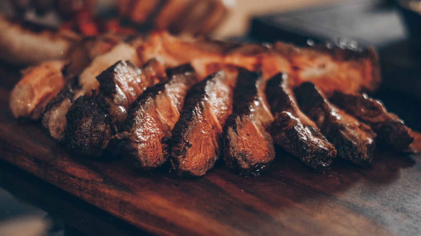 Viande tranchée épais sur planche de bois, lumière chaude